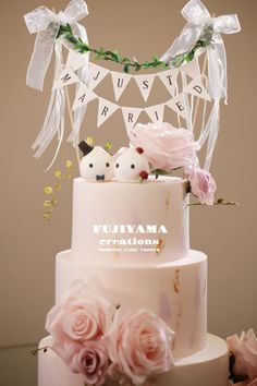 a wedding cake decorated with flowers and bunting