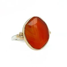 The incredible texture in this striped Rosecut Carnelian is truly one of a kind. Like a flowing river of orange lava it is set in 14k yellow gold with accent beads and a freeform sterling silver band. Approximate stone size: 14mm x 17mm 5.8 cts Mohs Stone Hardness: 6 This one of a kind piece is handmade to in Emily's Hudson Valley studio. This piece is in stock and can be resized prior to shipping. If you have questions about sizing, shipping or need help deciding please reach out to us! Oval Carnelian Yellow Gold Jewelry, Carnelian Gemstone Jewelry Ring, Orange Carnelian Jewelry For Anniversary, Artsy Yellow Gold Jewelry With Carnelian Stones, Yellow Gold Carnelian Jewelry With Polished Finish, 14k Gold Orange Jewelry With Polished Finish, Orange 14k Gold Jewelry With Polished Finish, Classic Carnelian Ring Jewelry, Polished Carnelian Ring