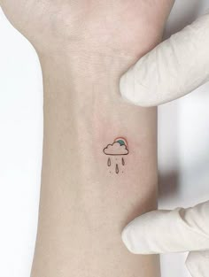 a person with a small tattoo on their left arm and the sky is raining behind them