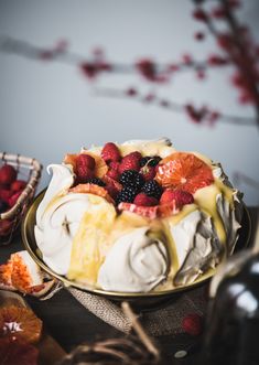 a cake sitting on top of a table covered in fruit