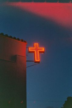 a large neon cross on the side of a building