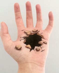 a person's hand with some black stuff on the inside of it and small holes in the palm