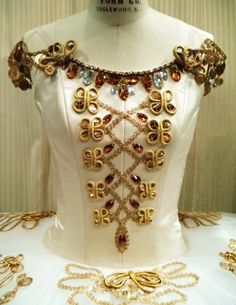 a white dress with gold chains and jewels on it