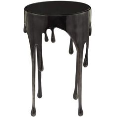 a black table with dripping paint on the top and bottom, it is shaped like an animal's legs