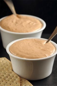 two white bowls filled with dip and crackers