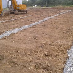 two construction trucks are parked in the dirt