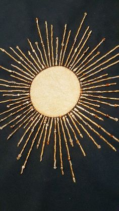 a sunburst made out of sticks on a black surface