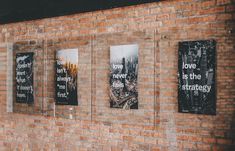 three black and white posters on a brick wall