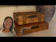 a woman standing next to two wooden boxes