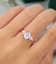 a woman's hand holding a ring with an amethorate and diamond