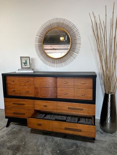 a dresser with drawers and a mirror on the wall