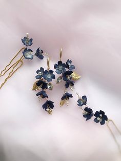 three hair pins with blue flowers on them