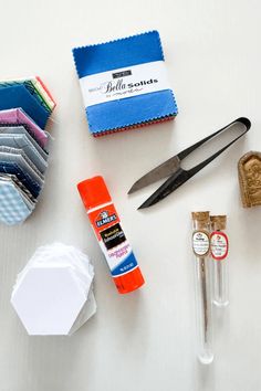 scissors, glue, and other craft supplies are laid out on a white table top