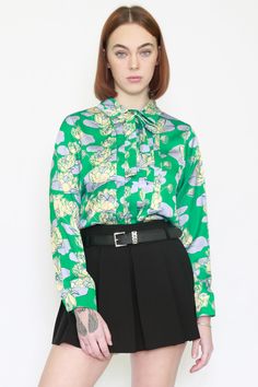 Introducing the SNOW XUE GAO Silk Floral Prints Green Blouse—a harmonious blend of sophistication and playfulness. This button-down beauty features a shirt collar with a chic necktie, while pleats in the front opening add a touch of elegance. The playful floral pattern in vibrant yellow makes it uniquely perfect for both work and special events. Crafted from luxurious silk, this blouse offers comfort and standout style. Effortlessly elevate your look with SNOW XUE GAO, where uniqueness and ease