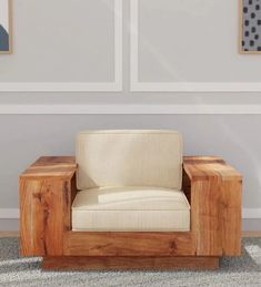 a wooden chair sitting on top of a carpeted floor next to two framed pictures