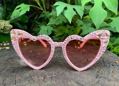 Heart shaped pink sunglasses with custom design crystal bling. Perfect for every day fashion/weddings/bride to be parties. Don't be surprised if your camera roll is full of selfies with these specs.  Each pearl crystal is hand placed to perfection, providing you with a look that will never go out of style. Note: Each pair of glasses is hand-crafted so individual peal patterns may vary ever so slightly from the pictures.  Frame: Acrylic Gems: Pink Crystals Style: Vintage Designer Retro Cat Eye Sunglasses Glamorous Pink Tinted Sunglasses, Pink Heart-shaped Party Sunglasses, Glamorous Pink Sunglasses For Party, Glamorous Pink Party Sunglasses, Every Day Fashion, Frame Acrylic, Heart Glasses, Day Fashion, Shaped Sunglasses