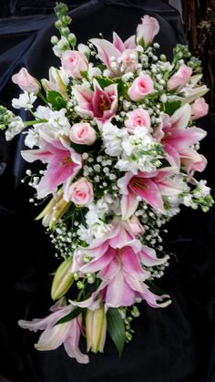 a bouquet of pink and white flowers on a black cloth