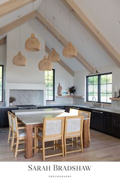 an open kitchen and dining room area with wood flooring, white walls and vaulted ceiling