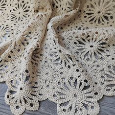 crocheted doily is laying on the floor next to a piece of cloth