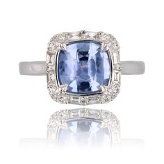 a ring with an oval cut blue stone surrounded by small white diamonds on the sides