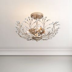 a chandelier hanging from the ceiling in a room with white walls and flooring