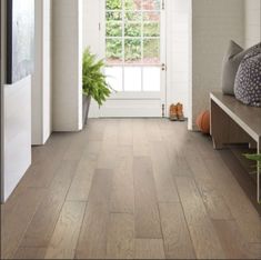 a hallway with white brick walls and wood flooring