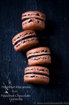 four chocolate macarons stacked on top of each other with the words hazelnut chocolate