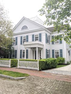 a large white house with blue shutters on the front