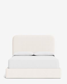 a bed with white sheets and pillows on it