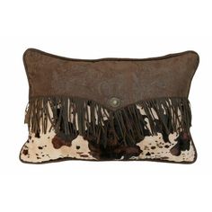 a brown and white cowhide pillow with fringes on the front, sitting on a white background