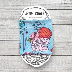 the label for skin coat's knitting kit sits on a wooden surface with yarn and needles