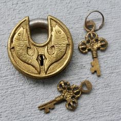 two antique keys and a keyring on a white surface