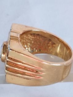 This Men's Gold Tone Art Deco Ring is now being listed just in time for Father's Day. The ring is made in a gold tone metal with a round setting with a Cubic Zirconia at the center. Tiny round glass rhinestones are hand set in pairs of 2 in individual pockets. There is no hallmark on this handsome ring but it is in great vintage condition and will arrive in a ring box with FREE SHIPPING. Size: 10.5 Material: Gold Tone Metal, Round Glass Cubic Zirconia, Tiny glass Rhinestones No hallmark Ring box Vintage Gold Enamel Ring Stamped 14k, Vintage Gold Round Cluster Ring, Gold Jewelry With Bezel Setting And Wide Band, Antique Gold Diamond Ring Collectible, Classic Gold Enamel Ring 14k, Classic Gold Enamel Ring Stamped 14k, Vintage Signet Ring With Prong Setting, Vintage Gold Diamond Ring For Collectors, Vintage Gold Cluster Ring Hallmarked