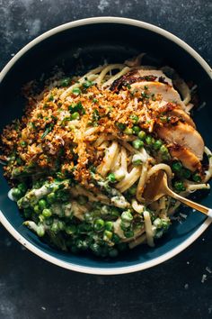 a blue bowl filled with pasta and peas