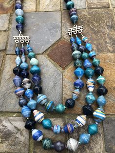 a multi strand beaded necklace on a stone floor