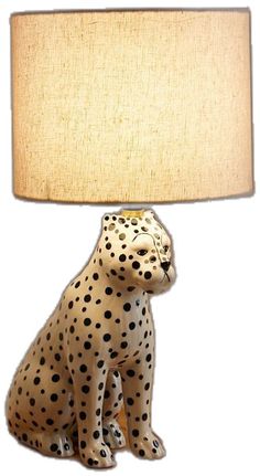 a lamp that has a leopard sitting on top of it with a light shade over it