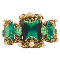 Possibly as old as the 1800s or a later Baroque-revival imperceptible reproduction, this antique handcrafted gilt silver filigree-frame textured-chain link bracelet likely originated in the European region of Austria-Hungary-Germany. We partly base this on its brilliant blue-green glass jewels in the rare trace-mineral saturated color of authentic alkaline Columbian emeralds. Including a decorative box-clasp, the ornate bracelet also features 14 prong-set round white pearls mostly mounted on the open-work filigree and 6 marquise-cut vanadium chrysoberyl mounted on both sides of the three linked frames. Along with the shifting shadows of the partly reflective filigree, the refracted light cast sideways by the paler lime-green beryl through the emerald-cut and scissor-cut vivid-glass jewels Luxury Heirloom Baroque Jewelry, Luxury Jewelry With Historical Baroque Design, Refracted Light, Perforated Plate, Baroque Jewelry, Filigree Frame, Austria Hungary, Columbian Emeralds, Scissor Cut