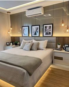 a bedroom with a bed, nightstands and pictures hanging on the wall above it