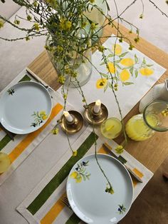 the table is set with yellow flowers and plates