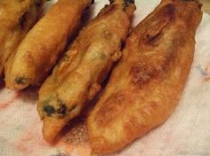 four fried food items are on a paper towel