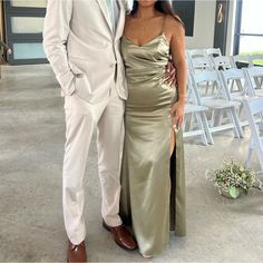 a man and woman standing next to each other in front of rows of white chairs