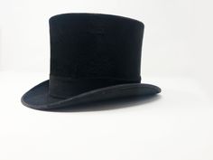 Genuine Top Hat by Tress & Co of London, Made in England 6 7/8 Black ribbon detailing, white silk interior. 6 7/8 is a very small size for men, and it actually fits me- very well, which is why I have marked as unisex. The likelihood of fitting women and smaller people are much higher. Gentleman Jack this hat today! Why? Because it's extremely elegant. Made in England Condition: GOOD ABOUT TRESS AND CO Cooper Tress Snr. (1787-1869) founded the Tress & Co. hat firm in 1846. He was joined a Classic Top Hat For Royal Ascot With Short Brim, Classic Short Brim Top Hat For Royal Ascot, Fitted Classic Top Hat For Evening Events, Fitted Classic Top Hat For Evening, Luxury Formal Top Hat With Flat Brim, Luxury Flat Brim Top Hat For Formal Events, Luxury Fitted Top Hat With Short Brim, Elegant Formal Top Hat, Fitted Top Hat With Flat Brim For Formal Occasions