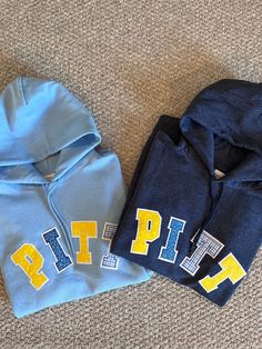 two sweatshirts are laying on the floor next to each other, one is blue and yellow