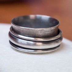 International deliveries in 2-4 business days as standard shipping. Totally handmade from 925 solid sterling silver. A rustic sterling silver ring with a big wide band and three silver spinners. Two of them are made by 1.5 mm sterling silver wire and the third by half-round wire 4mm in width and 2 mm thick. A rustic men's ring! It comes gift wrapped and ready for giving! ✿REGISTERED MAIL WITH TRACKING NUMBER ✿All of our jewelry are made to order. Allow for about a week for the jewelry to be made Silver Sterling Silver Wide Band Ring, Silver Thick Band Stackable Rings, Silver Stackable Wide Band Ring, Silver Stackable Jewelry, Rustic Mens Rings, Chunky Silver Rings, Jewelry Chunky, Rustic Rings, Mens Gold Rings