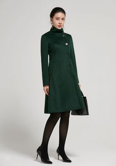 "Elegant fit and flare coat by Xiaolizi. Lovely detail with the buttons and twin waist pockets. Stand up collar and fully inside lined. Made in soft dark green wool fabric. DETAIL * 50% wool blend, 50% fiber,nylon * fully satiny lining, more nice to the touch body * stand collar * Long sleeve * Two seam big pockets that can slide your whole hands in it * single breasted front with button and snap closure * A Line coat, vintage wool coat * above knee length * Lean More about the items From the FA Fall Knee-length Single-breasted Outerwear, Solid A-line Outerwear For Fall, Fall A-line Single Breasted Outerwear, Knee-length Single Breasted Outerwear For Fall, Single-breasted Knee-length Outerwear For Fall, Knee-length Single-breasted Outerwear For Fall, Knee-length Single Breasted Winter Outerwear, Winter Wool Coat For Office, Knee-length Winter Outerwear For Work