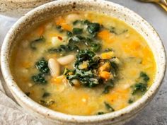 a bowl of soup with spinach and carrots