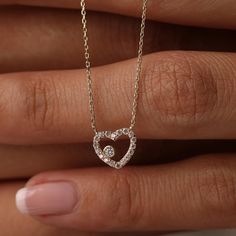 This 14K Gold Open Heart Necklace with CZ Pave is a beautiful and versatile piece, perfect for any occasion. Its minimalist design and sparkling cubic zirconia accents make it suitable for both daily wear and special events. Ideal as a birthday gift or a present for a bride, this necklace symbolizes love and affection. Pair it with matching jewelry for a coordinated look. Its quality craftsmanship and timeless design ensure it will be cherished for years to come. Product Features: * Made to Order: Crafted specifically to your preferences. * Gold KT: 14K Solid Gold (not filled, not gold vermeil, not plated) * Gold Color Options: Choose from Yellow, Rose, or White Gold, tailoring the necklace to your preferred style. * Gemstone: Adorned with a dazzling Cubic Zirconia, adding a touch of brill Gold Open Heart Necklace, Open Heart Necklace, Solid Gold Chains, Jewelry Christmas, Matching Jewelry, Christmas Gift Jewelry, Open Heart, Heart Jewelry, Heart Necklace