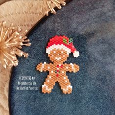 a cross stitch christmas ornament with a gingerbread man on it