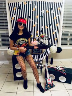 a woman sitting on top of a chair wearing fishnet stockings and holding a guitar