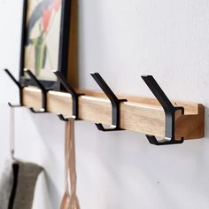 a wall mounted coat rack with three hooks